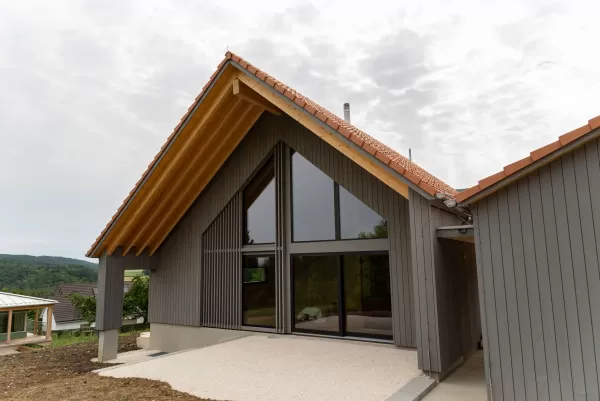 Truberholz-Haus Einfamilienhaus, vor vergraute Aussenschalung stehend, Innen Truberholz-Wände sichtbar, Dübel sichtbar, helles Haus mit grossen Fensterfronten in die Gehrung, eingekleidete Treppe, Haus mit Ziegel, inkl. Garage