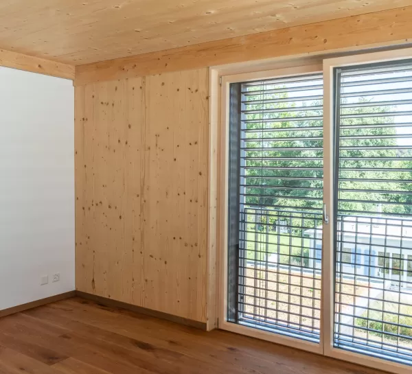 Mehrfamilienhaus Truberholzhaus Recherswil, Schweizer Holz, Truberholzwände sind nicht sichtbar, die Dübel sind nicht sichtbar, Fassade ist vorvergraut, es hat eine Attikawohnung, im Erdgeschoss und Obergeschoss hat es Loggaeinschnitte (Terrasse, Balkon), moderner Neubau, auf dem Dach ist ein Sonnensegel, Flachdach mit Solarpanel, es hat kein Keller dafür ein zusätzliches Gebäude mit Autounterstand und Lagerraum, Umschwung mit Rasen